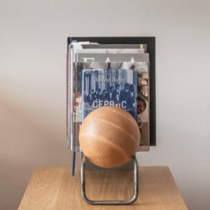 Minimalist rack with books and supporting wooden ball.