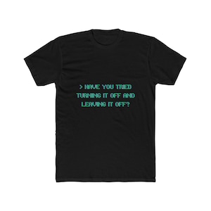 Op de afbeelding: Een zwart t-shirt met korte mouwen en gepixelde lichtblauwe tekst op de borst met de tekst: > HAVE YOU TRIED TURNING IT OFF AND LEAVING IT OFF? Het kledingstuk heeft een ronde hals en een standaard pasvorm met een strak ontwerp.