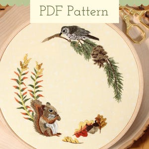 May include: Embroidered PDF pattern with a squirrel, bird, pinecone, and autumn leaves. The design is set within a wooden embroidery hoop. The text "PDF Pattern" is at the top. Includes gold scissors.