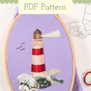 May include: A red and white striped lighthouse with a white beam of light, embroidered on a purple fabric background. The lighthouse is surrounded by green and white waves.