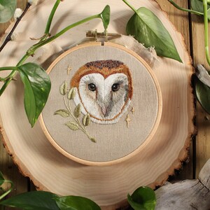 embroidery of an owl surrounded by leaves and branches