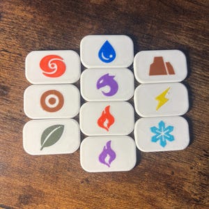 May include: A collection of ten rectangular white tiles featuring various colored icons. The icons include a blue water drop, a brown mountain, a red swirl, a brown target, a purple dragon head, a yellow lightning bolt, a green leaf, a red flame, a blue snowflake, and a purple flame.