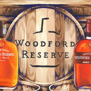May include: Two bottles of Woodford Reserve bourbon whiskey, one labeled "Distiller's Select" and the other "Double Oaked", are displayed in front of three wooden barrels. The barrels are labeled "Woodford Reserve".