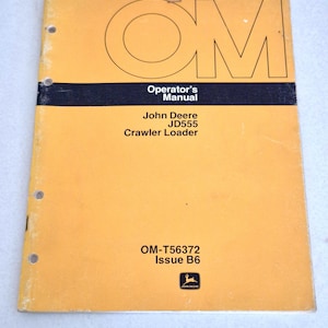 May include: A yellow John Deere JD555 Crawler Loader operator's manual with black text. The cover features the large letters OM, the title Operator's Manual, the model name, the code OM-T56372 Issue B6, and the John Deere logo at the bottom.