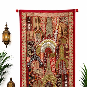 Op de afbeelding: Een rechthoekige wandhanger met een levendige rode achtergrond, voorzien van ingewikkeld patchwork-borduurwerk, gouden metaaldraad, lovertjes en spiegelaccenten. Het ontwerp bevat diverse geometrische en florale patronen met kwastjes.