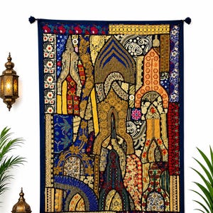 Puede incluir: Un tapiz rectangular que presenta un mosaico de paneles de tela bordados en tonos azul profundo, dorado, rojo y blanco. El diseño incorpora patrones geométricos intrincados, motivos florales y detalles en hilo metálico.