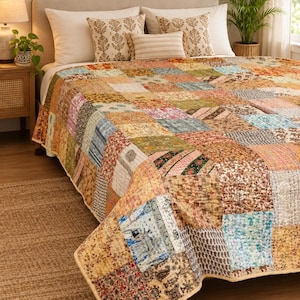 Könnte beinhalten: Eine Patchwork-Steppdecke mit einer Vielzahl quadratischer Stoffblöcke in verschiedenen Farben und Mustern, darunter Blumen-, geometrische und Paisley-Drucke. Die Decke ist mit sichtbaren Nähten versehen, die eine strukturierte Oberfläche erzeugen.