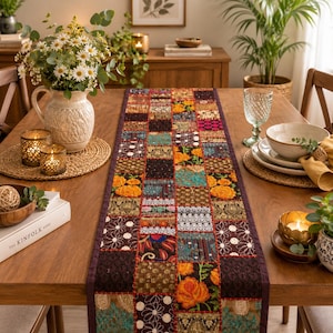 Peut inclure: Un chemin de table rectangulaire composé d'un assemblage de carrés de tissu aux couleurs vives, notamment orange, bleu sarcelle, doré et brun foncé. Il est orné de broderies complexes, de paillettes et de motifs floraux.