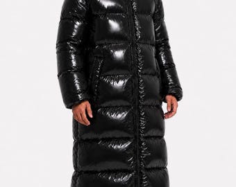 May include: A long, black, shiny, quilted puffer coat with a full-length front zip and an integrated hood that covers the head and neck, featuring a small cutout opening for the eyes. The coat has a glossy finish and horizontal baffles.