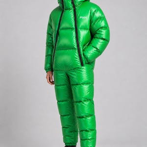 Op de afbeelding: Een felgroene, gewatteerde en geïsoleerde jumpsuit bestaande uit een jack met capuchon, een zwarte ritssluiting aan de voorzijde en de witte tekst PXH op de borst, gecombineerd met een bijpassende gewatteerde broek en zwarte veterschoenen.