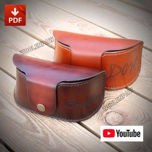 May include: Two semi-circular leather cases for eyewear, one in a dark brown finish with the name "Buckchen" engraved, and one in a lighter tan finish with the name "DON" engraved. Both feature a single metal snap button closure.