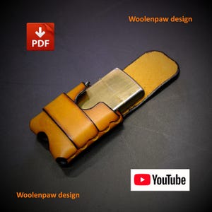 Può includere: Una custodia per accendino in pelle color cuoio con un accendino in metallo color ottone inserito all'interno. La custodia presenta una chiusura a patta e bordi scuri. L'immagine include il testo Woolenpaw design, un'icona PDF e il logo YouTube.