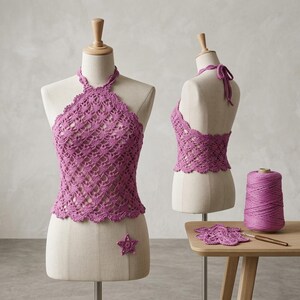 Puede incluir: Un top halter de ganchillo magenta con un patrón de bordes festoneados expuesto en dos maniquíes. Un maniquí muestra la vista frontal, el otro la espalda con tiras para atar. Se incluyen un carrete de hilo a juego, un ganchillo y un motivo de estrella.