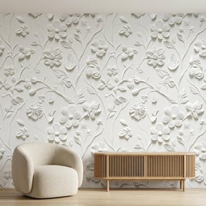 May include: A white wall covering featuring a raised, three-dimensional floral pattern with various flower shapes, leaves, and winding stems. The design creates a textured, monochromatic surface that covers the entire wall area.