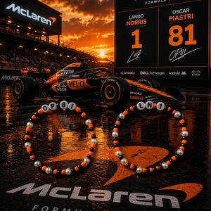 Peut inclure: Deux bracelets circulaires en perles alternant les couleurs noir, orange et blanc. L'un des bracelets affiche les lettres OP et le chiffre 81, tandis que l'autre affiche les lettres LN et le chiffre 1, en référence à l'équipe McLaren Formula 1.