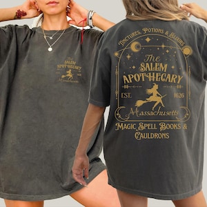 a woman wearing a gray t-shirt with a design on the back.