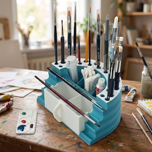 May include: A tiered blue and white plastic organizer featuring multiple vertical slots for paintbrushes, a central compartment for small tools, and a front drawer. The structure is semi-circular with horizontal stripes and holds various art supplies.