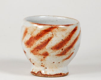 Yunomi, a ceramic cup, glazed in shino with hand marked decoration