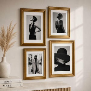 Może przedstawiać: Galeria ścienna składająca się z czterech prostokątnych złotych ramek zawierających czarno-białe fotografie modowe. Obrazy przedstawiają osoby w różnych pozach, w tym w sukience, widok z tyłu, płaszcz oraz kapelusz z szerokim rondem.