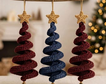 May include: Three hanging ornaments shaped like spiral Christmas trees. Two are dark red and one is navy blue. Each tree is topped with a small crocheted gold star and features a gold bead at the bottom point, suspended by a thin tan cord.