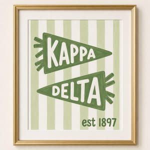 Peut inclure: Une impression d'art encadrée présentant deux fanions verts avec le texte blanc Kappa et Delta, sur un fond à rayures verticales vert clair et blanc, avec le texte est 1897 imprimé en vert dans le coin inférieur droit.