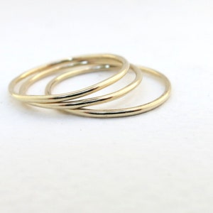 May include: Three gold-colored stacking rings, each with a smooth, rounded surface.
