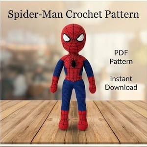 Puede incluir: Una muñeca de ganchillo hecha a mano de un superhéroe rojo y azul con un emblema de araña negro en el pecho y ojos blancos. El texto dice Spider-Man Crochet Pattern, PDF Pattern e Instant Download. La muñeca tiene un patrón de telaraña.
