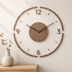 May include: A circular wall clock featuring a dark wood grain finish. The design includes a central circular wooden panel, a thin outer ring, and raised wooden numerals at the 12, 3, 6, and 9 o'clock positions, with thin wooden hands.