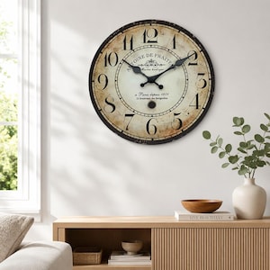 May include: A round wall clock with a distressed cream face, black Roman numerals, and black hands. The centre features the text Antoine De Praite, Maitres horloger, a Paris depuis 1801, 25 Boulevard des Batignolles in black script.
