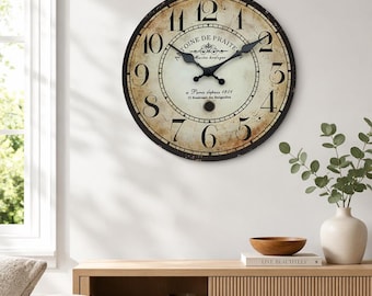 May include: A round wall clock with a distressed cream face, black Roman numerals, and black hands. The center features the text Antoine De Praite, Maitres horloger, a Paris depuis 1801, 25 Boulevard des Batignolles in black script.