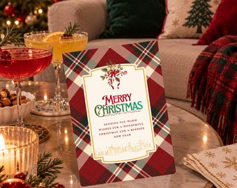 May include: A rectangular Christmas greeting card featuring a red, green, and white plaid pattern. The center displays a white panel with the text Merry Christmas, a holiday message, and a small illustration of a village and holly.
