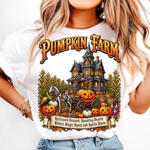Könnte beinhalten: Ein weißes T-Shirt mit einer Grafik eines Spukhauses, eines Skelettpferdes, das einen Wagen zieht, und Kürbissen. Der Text lautet PUMPKIN FARM oben und Hallowed Ground, Haunting Beauty Where Magic Roots and Spirits Roam auf einem Banner.