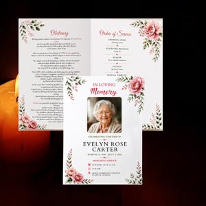 Könnte beinhalten: Ein Trauerprogramm mit einem Foto einer älteren Person, dem Text In Loving Memory, Evelyn Rose Carter und den Daten 14. März 1948 - 8. Juli 2026. Das Design enthält rosa Blumenakzente, grüne Blätter und einen Abschnitt für den Ablauf der Feier.