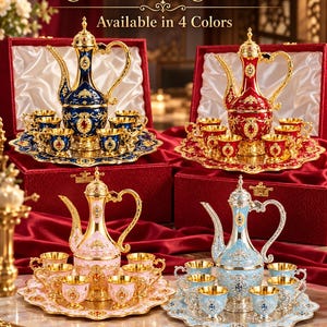 Könnte beinhalten: Vier Getränkesets, bestehend aus einer hohen, verzierten Kanne, sechs kleinen Tassen und einem passenden Serviertablett. Die Sets sind in Blau, Rot, Rosa und Hellblau gehalten und mit Gold- oder Silberfiligran sowie Schmucksteinen verziert.