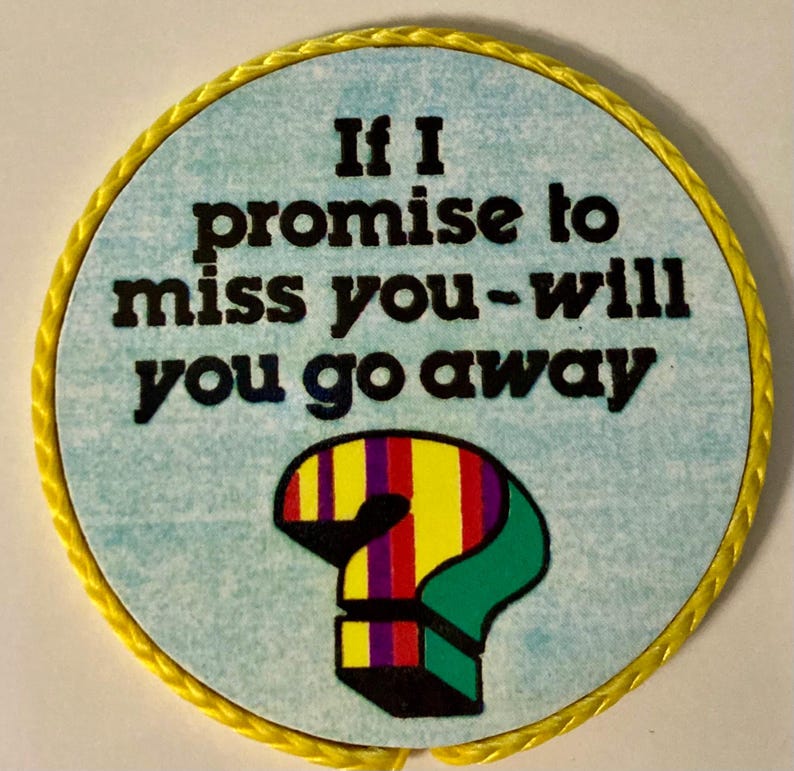May include: A circular sign with a light blue textured background and a yellow braided border. The black text reads, If I promise to miss you-will you go away. Below the text is a colorful question mark with vertical stripes of red, yellow, and purple.