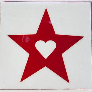 May include: A square, white background with a red star design. Inside the red star is a white heart shape. The edges of the square have a thin red border.
