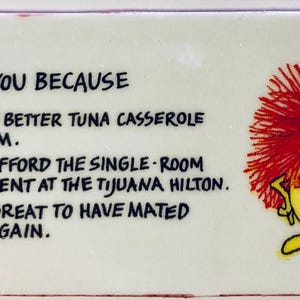 May include: A rectangular white plaque with the text "I LOVE YOU BECAUSE" and three humorous reasons. A cartoon character with red hair and a yellow body is on the right side.