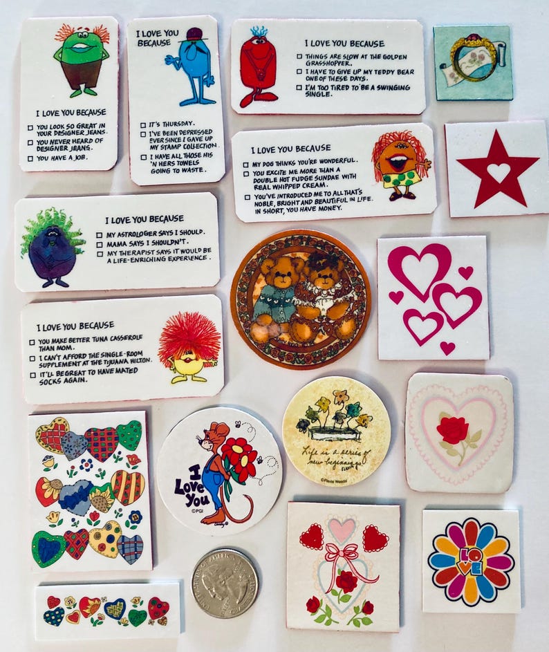May include: A collection of small, decorative items with various designs and text. The items include cartoon characters, hearts, and the phrase "I Love You Because." Colors include red, blue, green, and yellow. Some items are square, round, or rectangular.