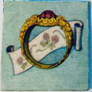 May include: A square image featuring a gold ring with a red gem on top, encircling a white scroll with pink floral designs. The background is a light blue, and the ring has intricate detailing.