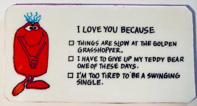May include: A rectangular white card with the text "I LOVE YOU BECAUSE" and three reasons listed below. A red cartoon character with blue hair and a smiling face is on the left side of the card.