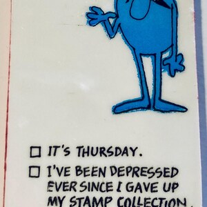May include: A rectangular card with the text "I LOVE YOU BECAUSE" above a cartoon character. The character is blue with a red hat and black mustache. Below are three check boxes with humorous reasons.
