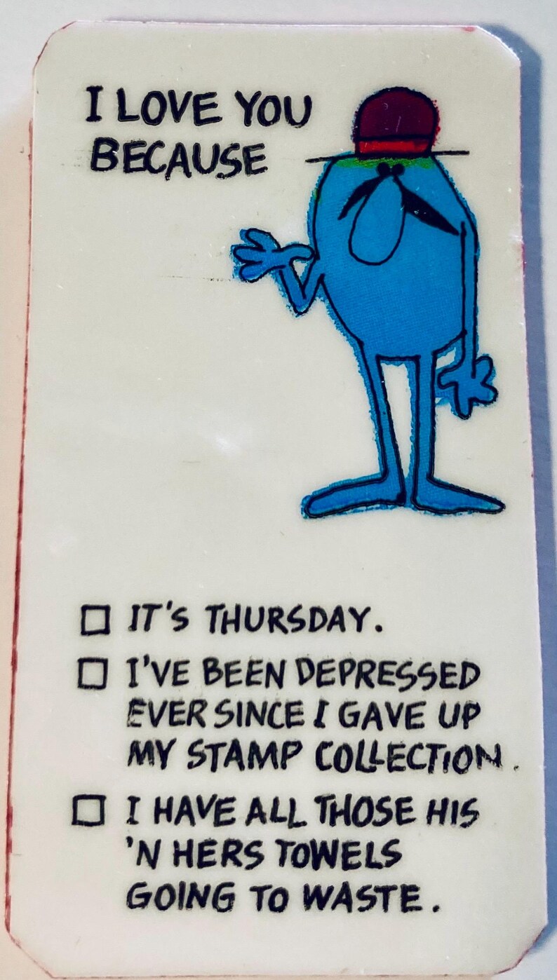 May include: A rectangular card with the text "I LOVE YOU BECAUSE" above a cartoon character. The character is blue with a red hat and black mustache. Below are three check boxes with humorous reasons.
