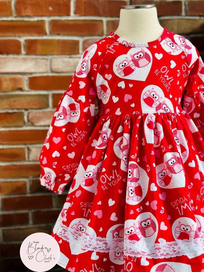 May include: Red dress with a white lace trim and a pattern of owls and hearts. The dress has the text "Owl Be Yours" repeated on it.