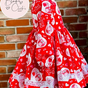 May include: Red and white dress with a Valentine's Day owl print. The dress has long sleeves and a white lace trim. The dress has the text "Owl Be Yours" repeated on the fabric.
