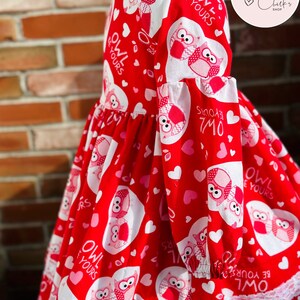 May include: Red dress with white owls and hearts. The dress has a white lace trim and the text "Owl Be Yours" is repeated throughout the design.