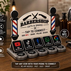 Peut inclure: Un présentoir NFC pour salon de coiffure avec un panneau crème portant le texte noir BARBERSHOP CUTS & SHAVES, encadré par deux poteaux de barbier rouge, blanc et bleu. Il comporte cinq icônes noires pour YouTube, TikTok, Facebook, WhatsApp et Google.