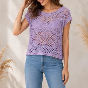 May include: A light purple short-sleeved top featuring an intricate openwork crochet pattern with a wide round neckline and a straight hem, paired with light blue denim jeans that have a classic five-pocket design and a button fly closure.