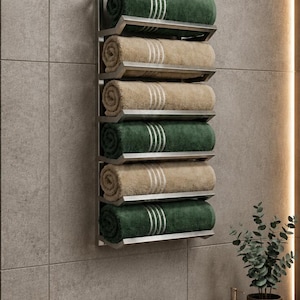 Puede incluir: Un toallero de pared de metal con seis estantes en ángulo, cada uno con una toalla enrollada. Las toallas alternan entre colores verde oscuro y beige, y cada toalla presenta tres rayas blancas finas cerca del borde enrollado.