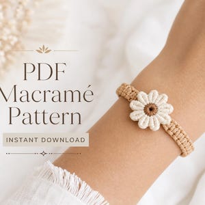 May include: A macramé bracelet featuring a central white flower with a brown centre, crafted from tan cord. The text on the image reads: PDF Macramé Pattern INSTANT DOWNLOAD. The design consists of a woven band with a floral motif.