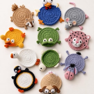 May include: A collection of eleven circular crochet coasters shaped like various animals, including a brown squirrel, blue bird, gray mouse, yellow duck, green frog, pink leopard, white goose, green turtle, purple donkey, penguin, and a tan dog with glasses.